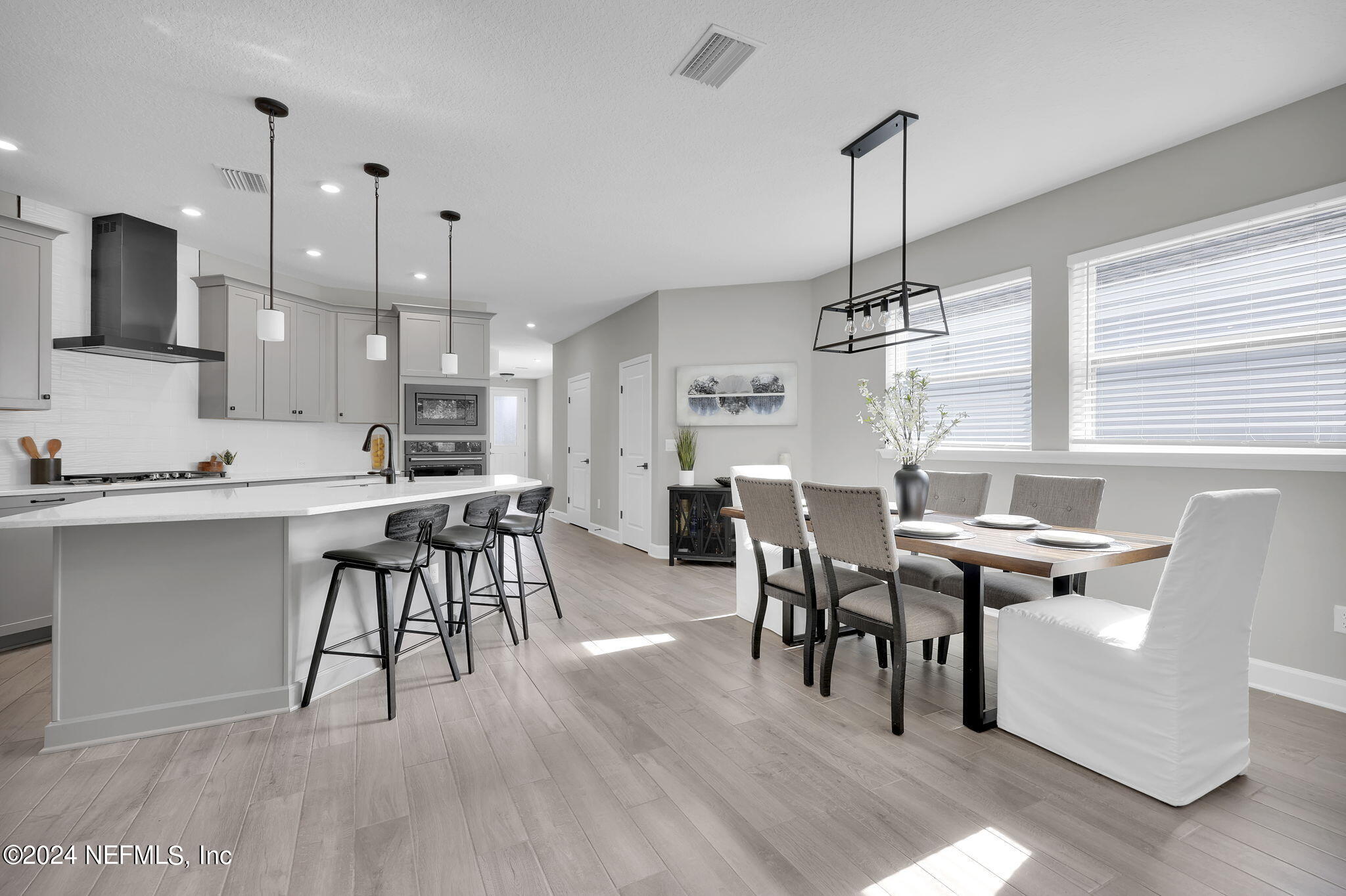 175 Windswept Way Street St. Augustine, FL 32092 - Photo 10 of 80 a open kitchen with stainless steel appliances granite countertop a stove top oven a sink a dining table and chairs with wooden floor