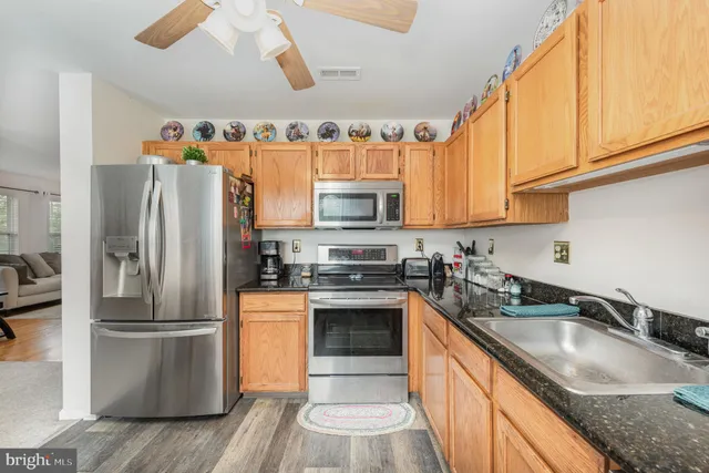 a kitchen with stainless steel appliances granite countertop a refrigerator and a stove top oven