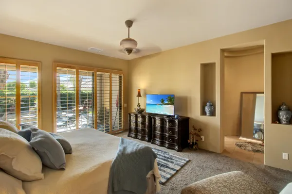 a bedroom with a bed and large windows