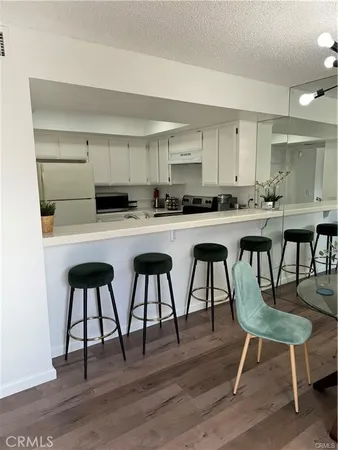 a kitchen with kitchen island a stove a table and chairs in it