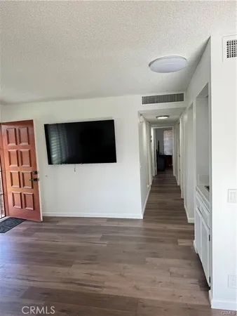 a view of a livingroom with an empty space and wooden floor
