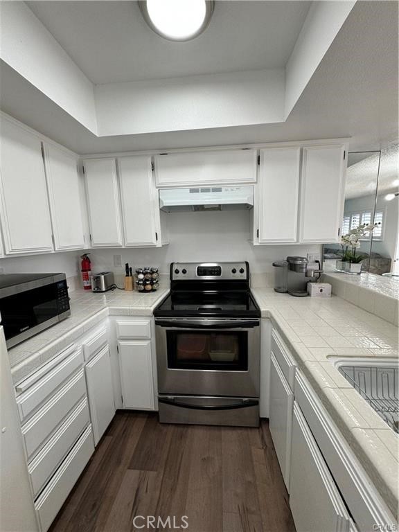 69520 Huerta Court Rancho Mirage, CA 92270 - Photo 9 of 25 a kitchen with stainless steel appliances a stove a sink and white cabinets