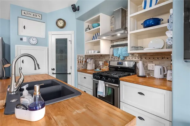 a kitchen with stainless steel appliances granite countertop a stove and a wooden cabinets