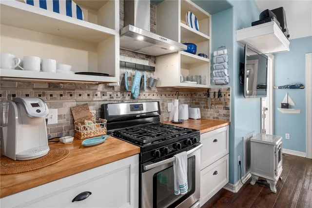 a kitchen with a stove center island with furniture and a chandelier