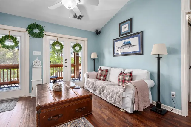 a living room with furniture a flat screen tv and a floor to ceiling window