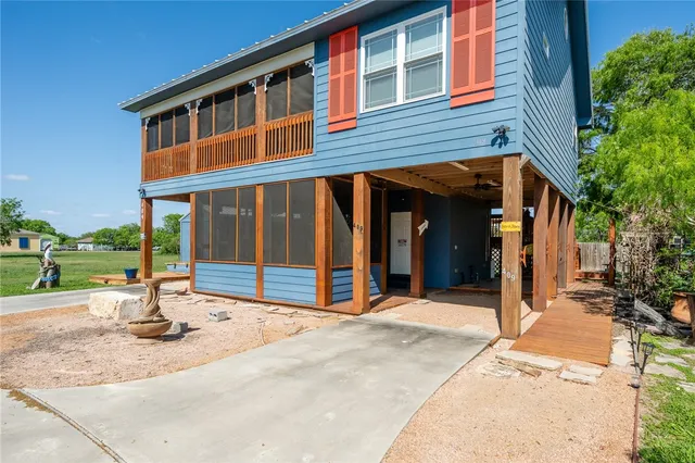 a view of a house with floor to ceiling windows and a basket ball poll
