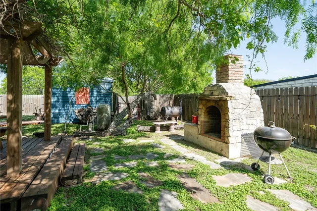 a front view of a house with a yard and a large tree