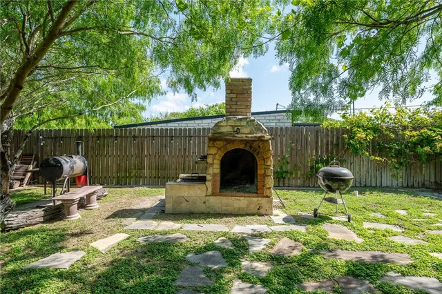 a view of a chair and table in backyard of the house