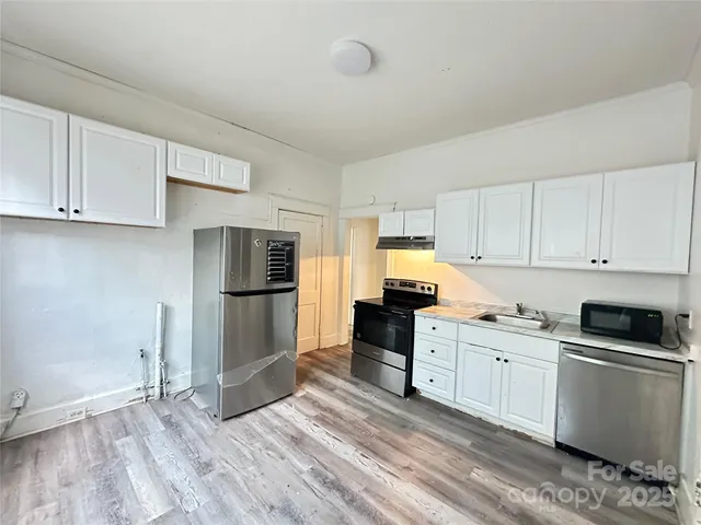 a kitchen with granite countertop a refrigerator stove and sink