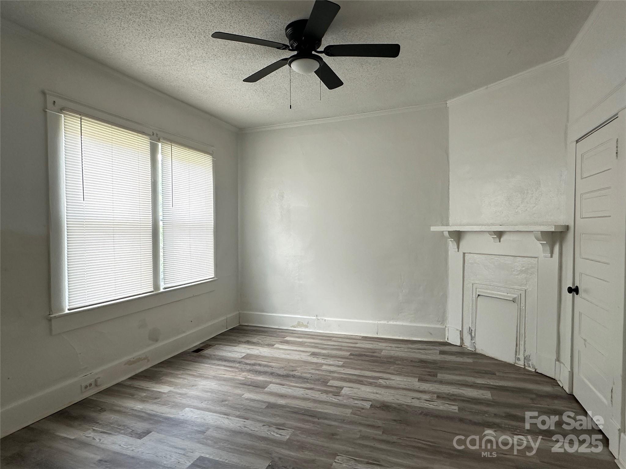 140 8th Street Winnsboro, SC 29180 - Photo 7 of 19 a view of empty room with wooden floor and fan