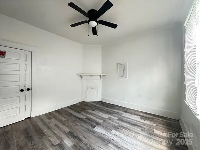 an empty room with a window and a ceiling fan