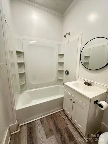 a bathroom with a tub sink and mirror