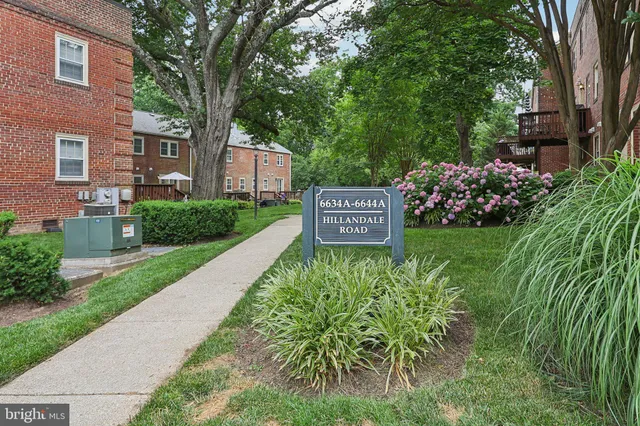 a sign board with a house and garden