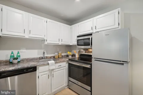 a kitchen with stainless steel appliances granite countertop a refrigerator sink and microwave