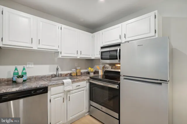 a kitchen with stainless steel appliances granite countertop a refrigerator sink and microwave