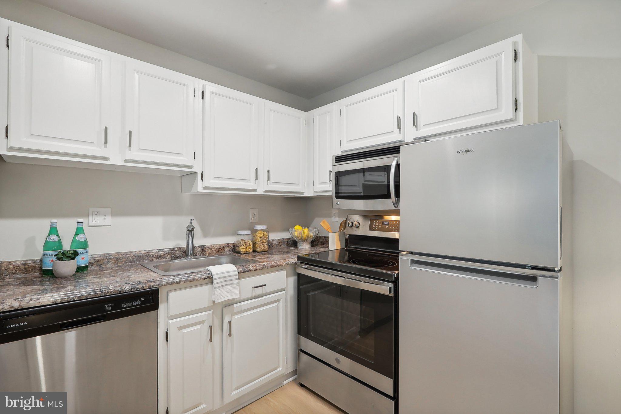 6638 A Hillandale Road, Unit 53A Chevy Chase, MD 20815 - Photo 7 of 26 a kitchen with stainless steel appliances granite countertop a refrigerator sink and microwave