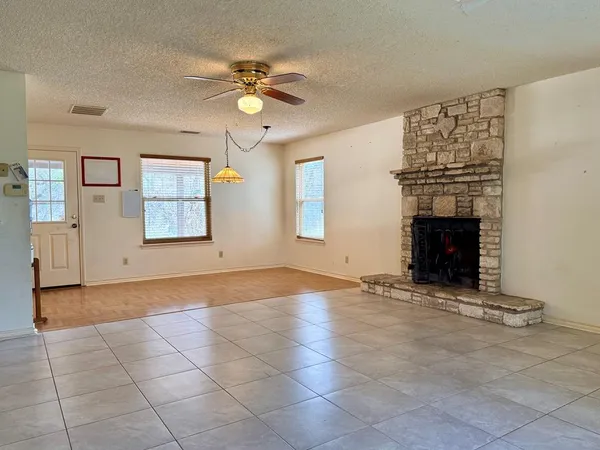 a view of an empty room with a fireplace and a window