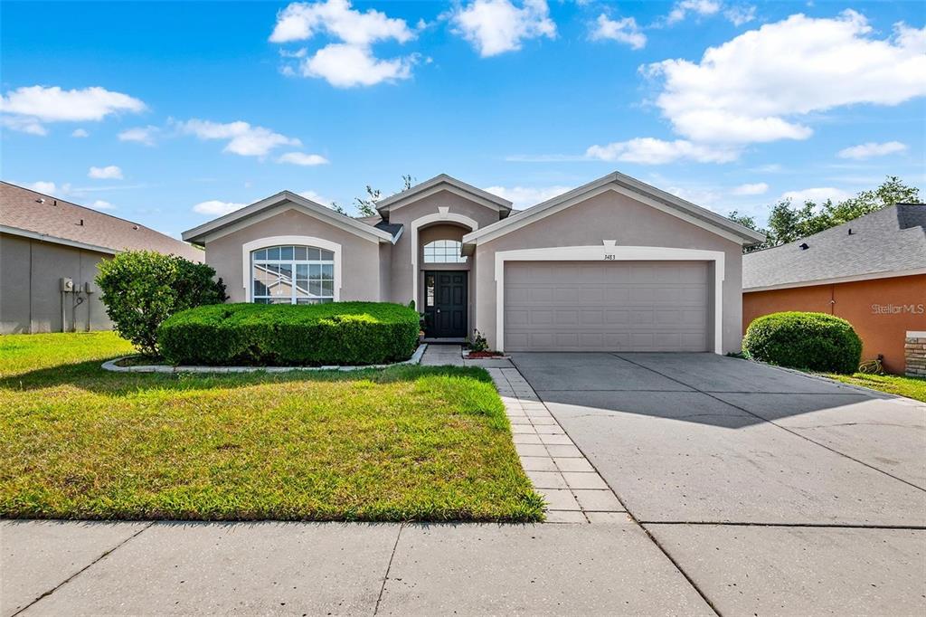 3483 Beaumont Loop Spring Hill, FL 34609 - Photo 1 of 14 a front view of a house with garden