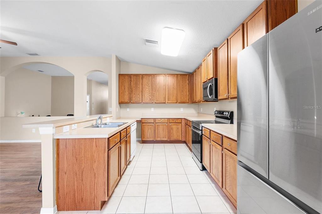 3483 Beaumont Loop Spring Hill, FL 34609 - Photo 5 of 14 a kitchen with stainless steel appliances a sink and a refrigerator