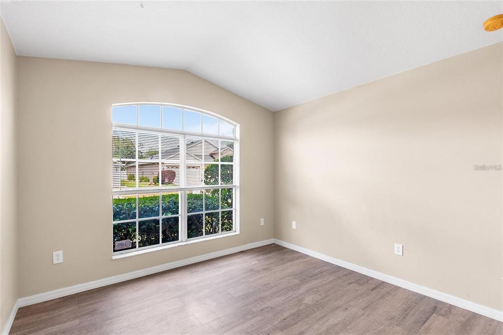 3483 Beaumont Loop Spring Hill, FL 34609 - Photo 9 of 14 an empty room with wooden floor and windows