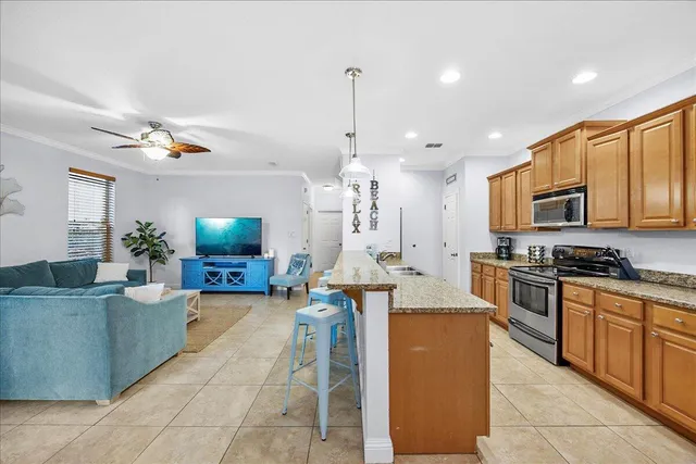 a large kitchen with stainless steel appliances granite countertop a stove a sink and a refrigerator