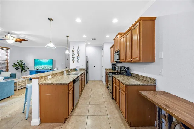 a kitchen with kitchen island granite countertop a sink and a refrigerator