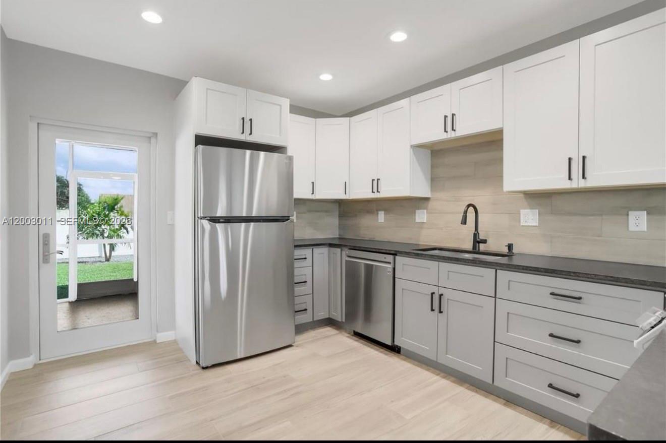 2550 North Dixie Highway, Unit 2570 Boca Raton, FL 33431 - Photo 2 of 16 a kitchen with granite countertop a refrigerator and a sink