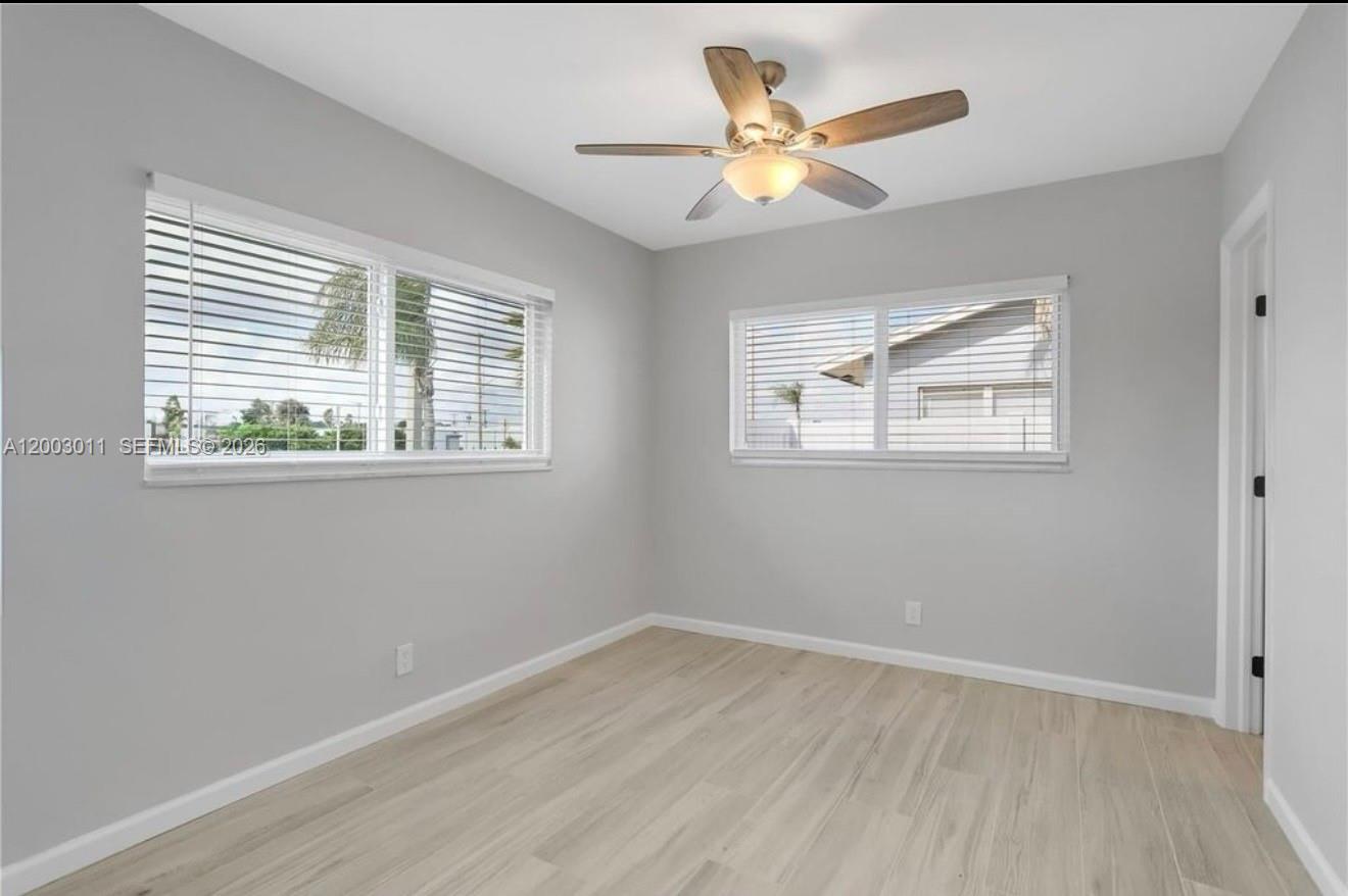 2550 North Dixie Highway, Unit 2570 Boca Raton, FL 33431 - Photo 8 of 16 an empty room with wooden floor and windows