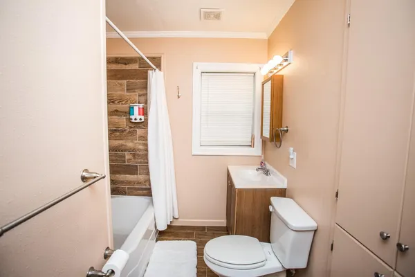 a bathroom with a sink a toilet a mirror and shower