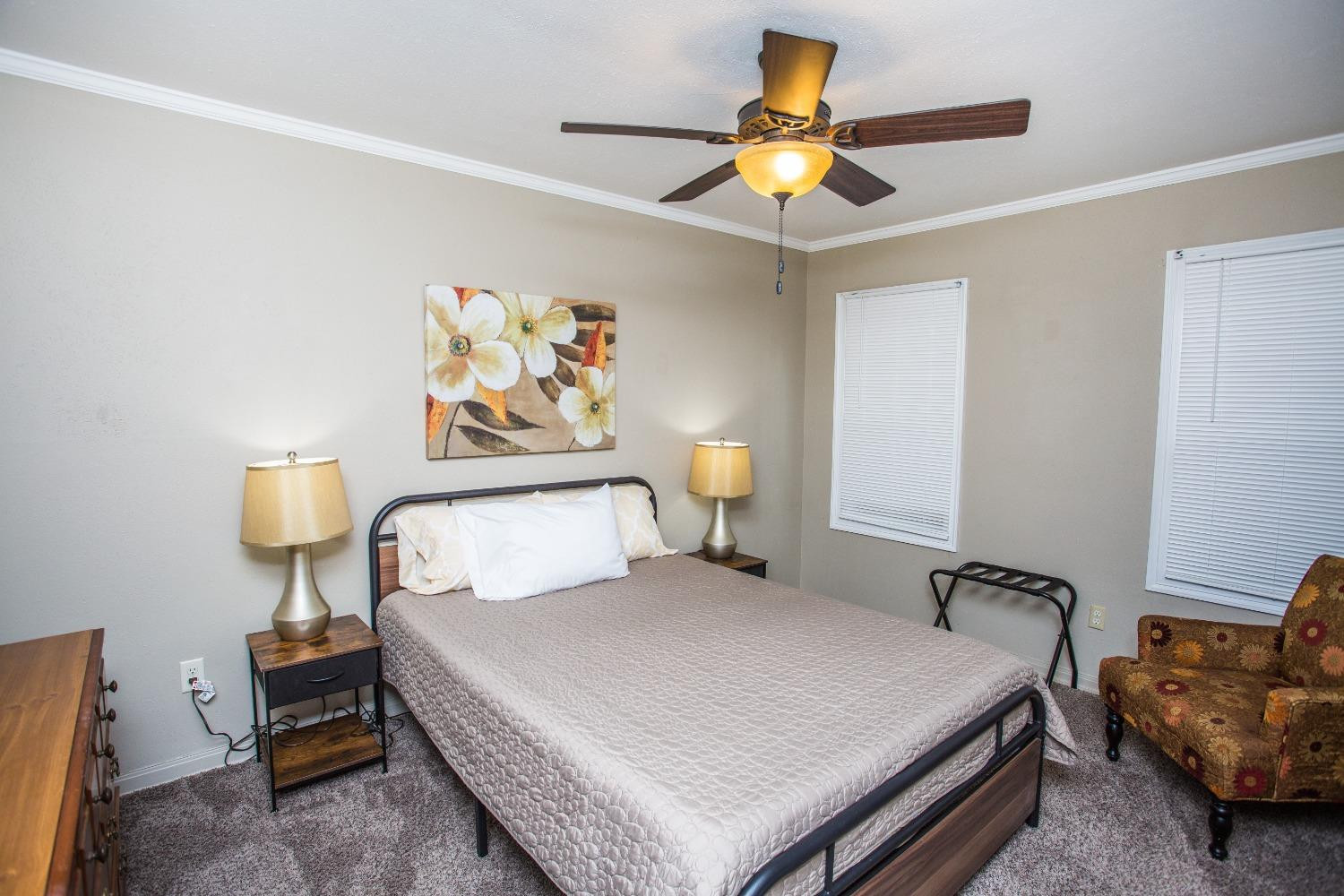 2418 23rd Street Lubbock, TX 79411 - Photo 9 of 17 a bedroom with a bed and a chandelier