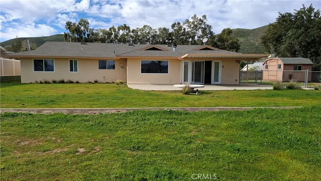 a front view of a house with a garden and trees