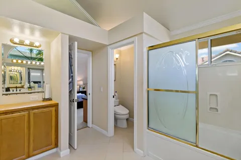 a bathroom with a granite countertop sink mirror and toilet