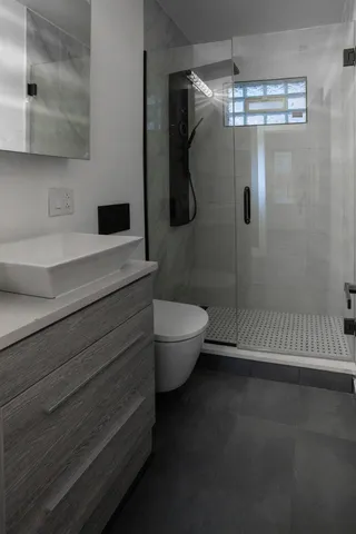 a bathroom with a toilet a sink and shower