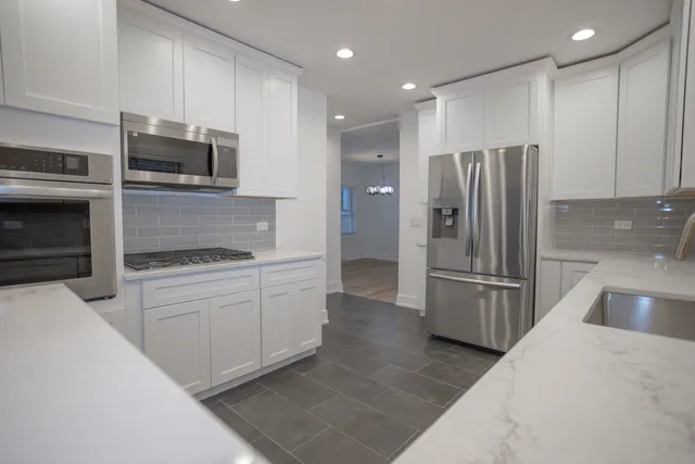 a kitchen with granite countertop a refrigerator stove and microwave