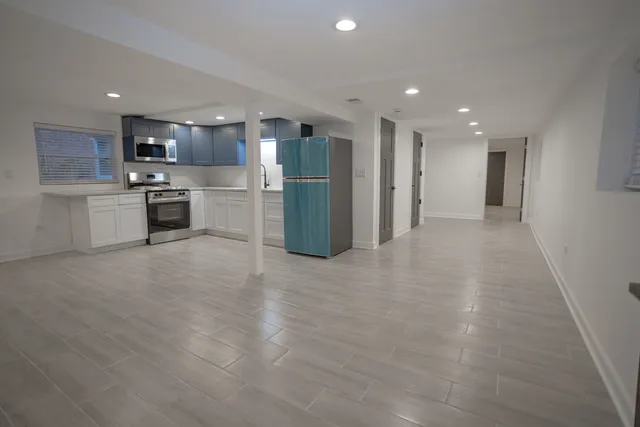 a view of kitchen with stainless steel appliances refrigerator oven and white cabinets