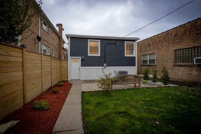 a view of a house with backyard and sitting area