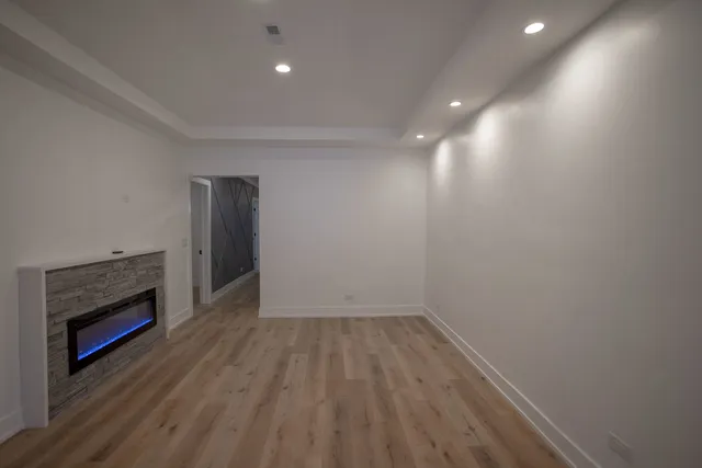 a view of empty room with wooden floor and fireplace