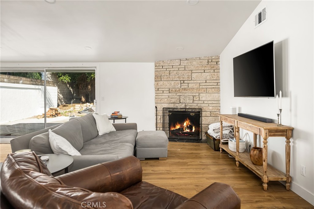 448 Princeton Drive Costa Mesa, CA 92626 - Photo 17 of 33 a living room with furniture a flat screen tv and a fireplace