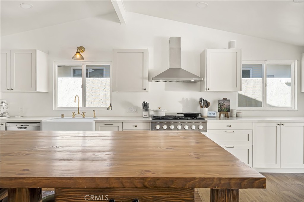 448 Princeton Drive Costa Mesa, CA 92626 - Photo 9 of 33 a kitchen with stainless steel appliances granite countertop wooden cabinets a stove top oven a sink and dishwasher with wooden floor