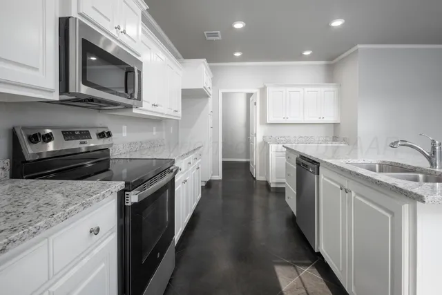 a kitchen with stainless steel appliances granite countertop a sink stove and cabinets
