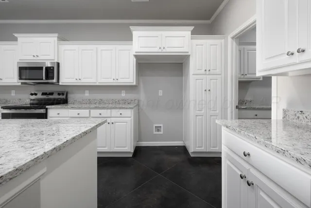 a kitchen with granite countertop a sink stove and refrigerator