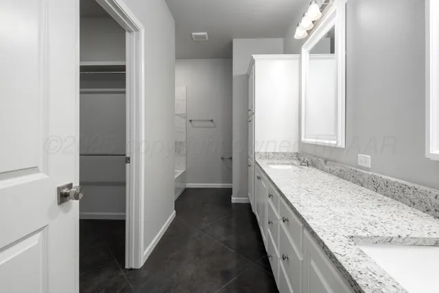 a bathroom with a granite countertop double vanity and a granite counter tops