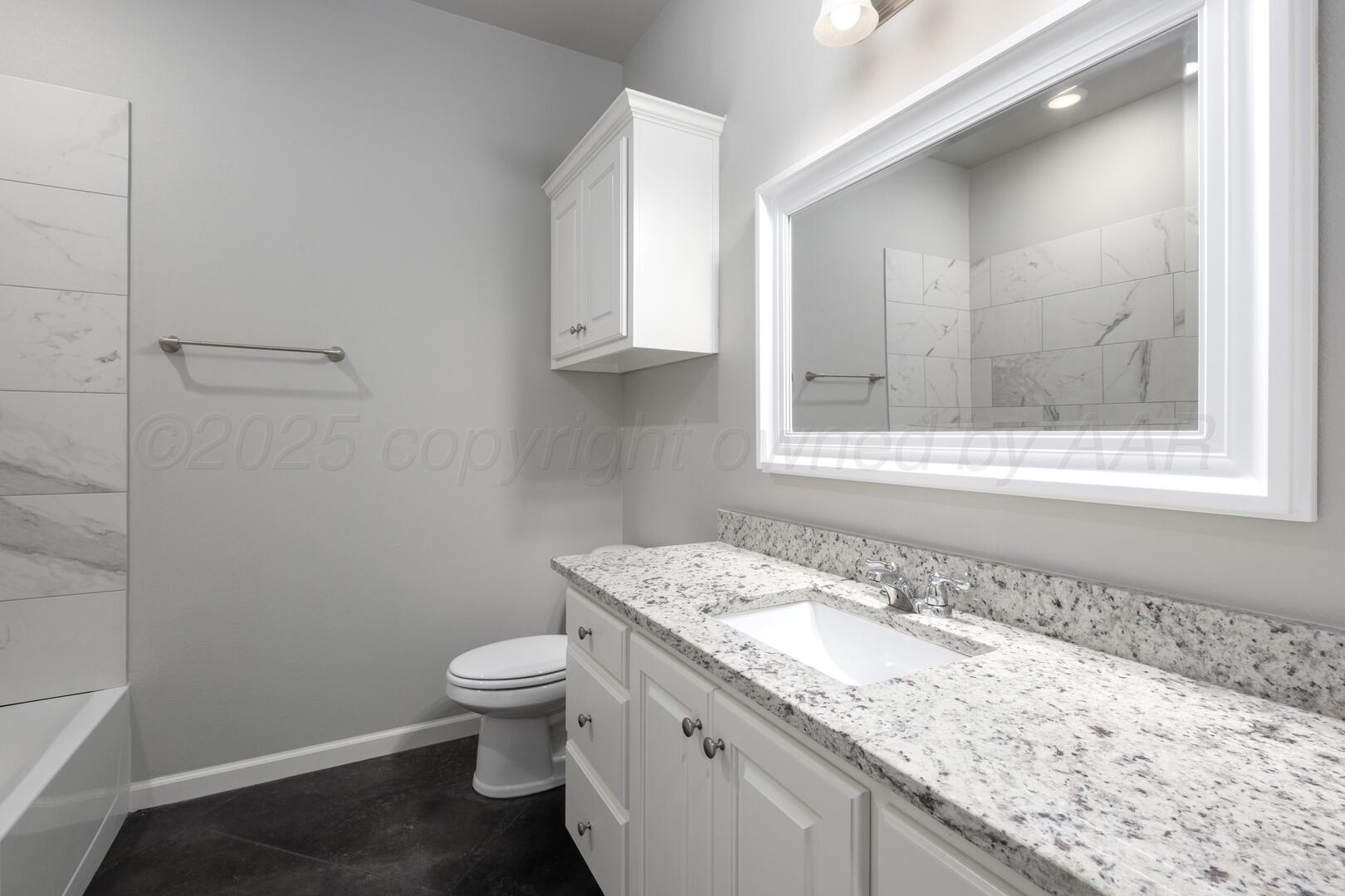 4600 Richardson Road Amarillo, TX 79118 - Photo 22 of 29 a bathroom with a granite countertop sink a toilet and a mirror