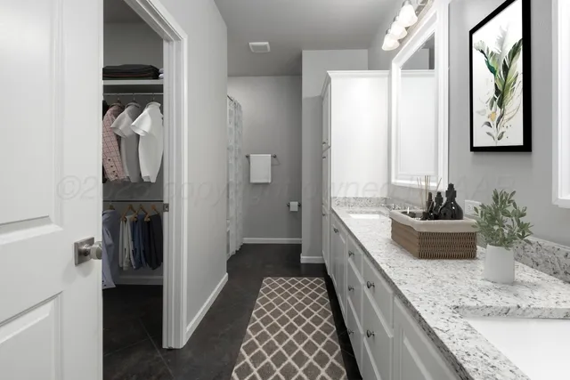 a large hall with a granite countertop sink a large mirror and a shower