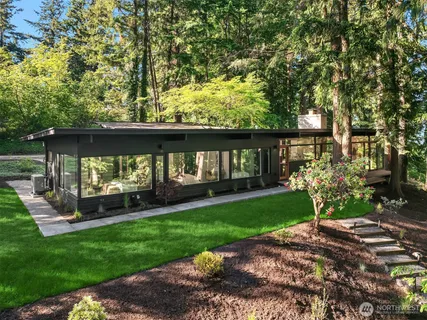 a view of a house with backyard and sitting area