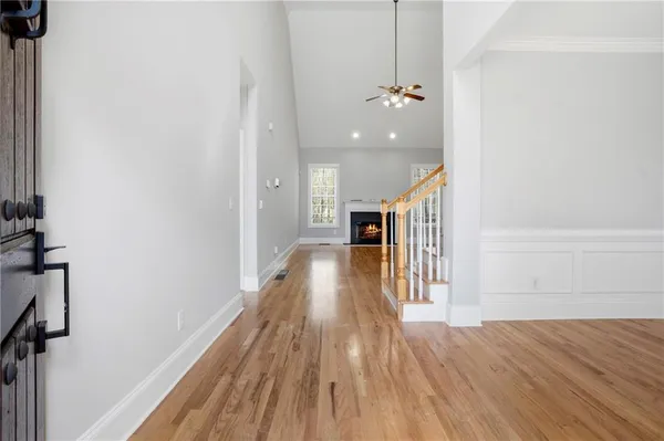 a view of an empty room with wooden floor fireplace and a window