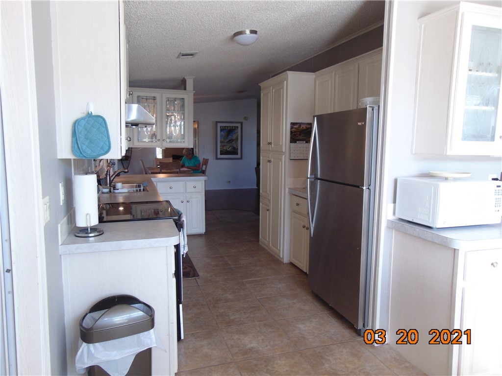 7615 Montauk Avenue, Unit R9 Micco, FL 32976 - Photo 11 of 36 a kitchen with stainless steel appliances granite countertop a refrigerator and a stove