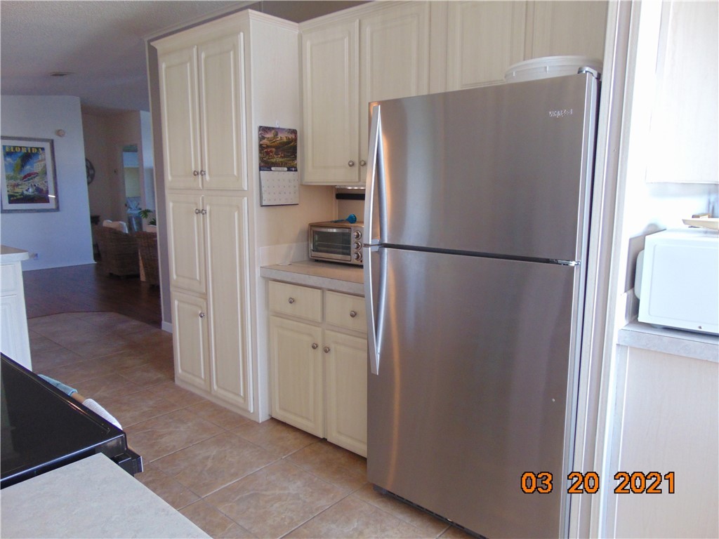 7615 Montauk Avenue, Unit R9 Micco, FL 32976 - Photo 13 of 36 a white refrigerator freezer and a stove sitting inside of a kitchen