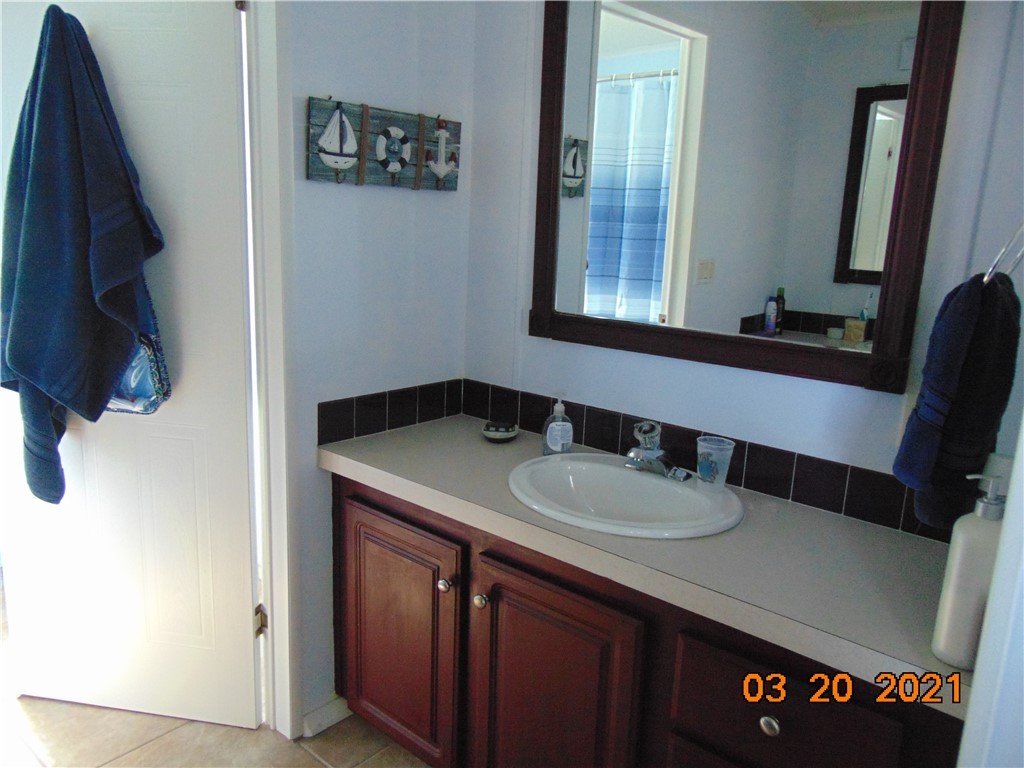 7615 Montauk Avenue, Unit R9 Micco, FL 32976 - Photo 26 of 36 a bathroom with a sink and a mirror
