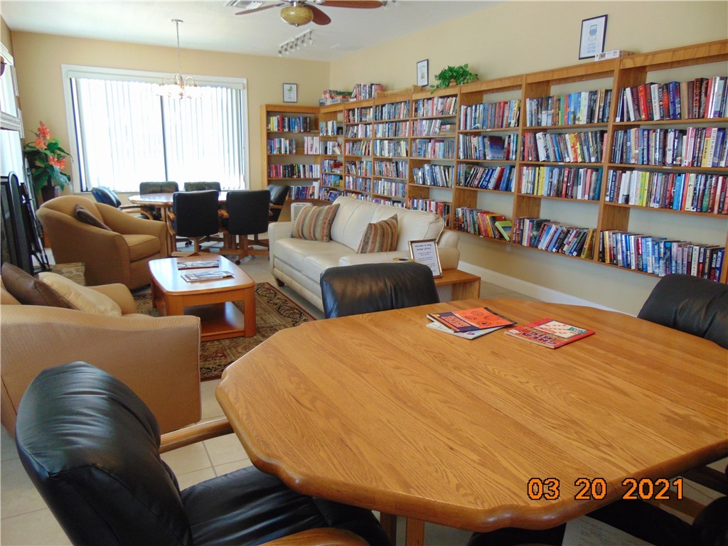 7615 Montauk Avenue, Unit R9 Micco, FL 32976 - Photo 35 of 36 a living room with furniture and a book shelf